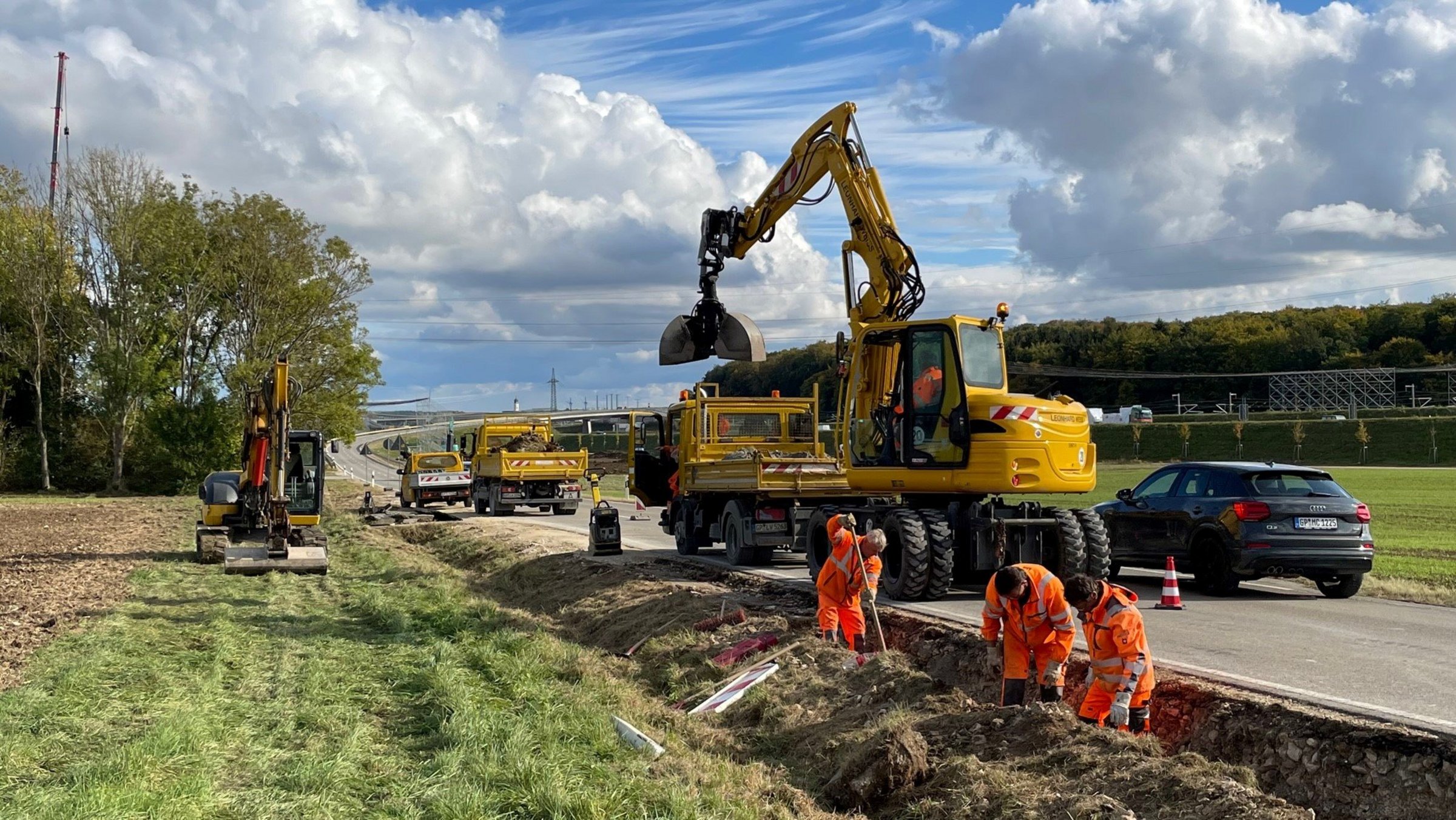 Baustellenfahrzeuge und Arbeiter beim Verlegen der neuen Leitungen