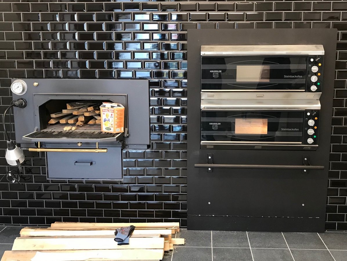 Holzofen und Elektroofen im Backraum des Backhauses